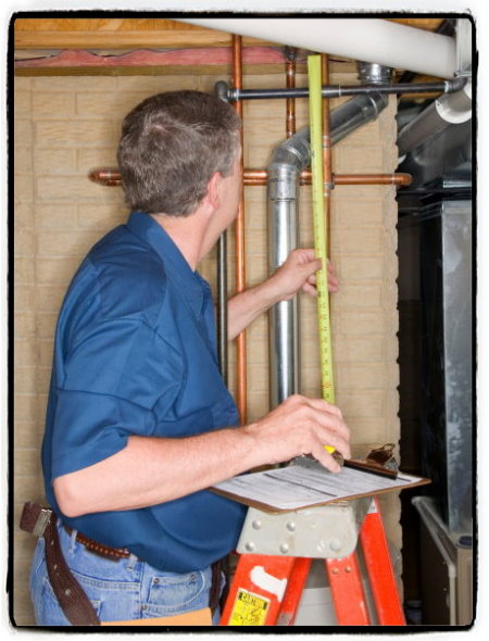 Home inspector inspecting pipes in a basement